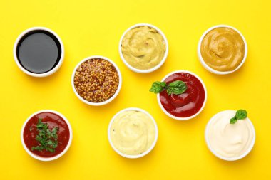 Sarı arka planda farklı soslar ve otlar var.