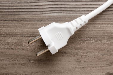 Tahta masasında fiş olan elektrik kablosu.