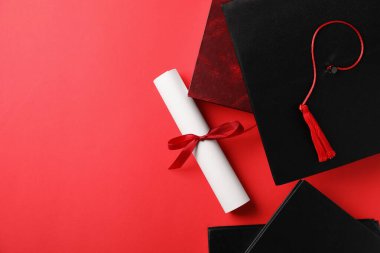 Diploma, mezuniyet şapkası ve kırmızı arka plan kitapları. Metin için boşluk