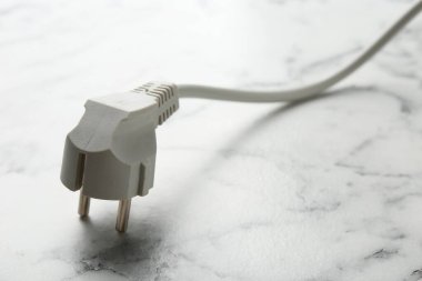 Beyaz mermer masa üzerinde fişi olan elektrik kablosu, yakın plan. Metin için boşluk