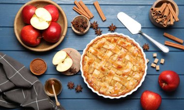 Lezzetli ev yapımı elmalı turta fırın kabında, malzemeler ve spatula mavi ahşap masada, düz yerde.