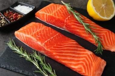 Somon fileto parçaları ve baharatlar gri masada, yakın plan.