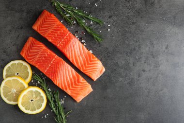 Somon fileto ve baharat parçaları gri masada, düz yerde. Metin için boşluk