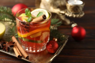 Lezzetli punç içeceği, baharatlar ve Noel süsü ahşap masada, yakın plan.