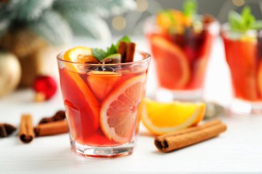Bardaklı, baharatlı ve Noel dekorlu kokteyl beyaz masada, yakın plan. Metin için boşluk