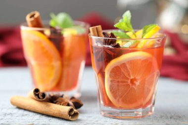 Lezzetli punç bardaklar ve baharatlar beyaz ahşap masa, yakın plan