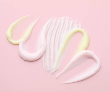 Pembe arka planda farklı kozmetik ürünleri örnekleri.