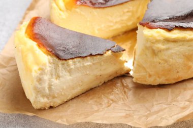 Açık gri desenli masada Bask peynirli keki kes, yakın plan.