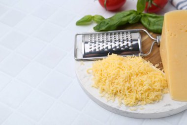 Izgara peynir, rende, fesleğen ve domatesler beyaz fayanslı masada, yakın plan. Metin için boşluk