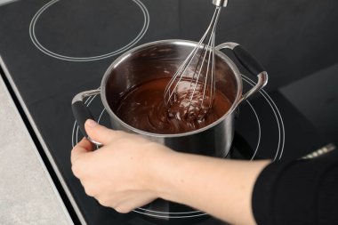 Erimiş çikolatayı demlikte karıştıran kadın, yakın plan.