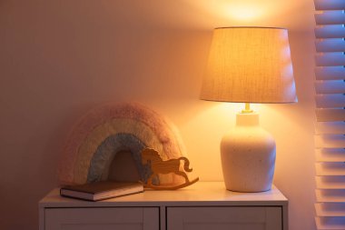 Giysiler, lamba, oyuncaklar ve dekorasyon geceleri bebek odasında. İç tasarım