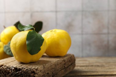 Tahta masadaki yapraklarla taze olgun ayva, yakın plan. Metin için boşluk