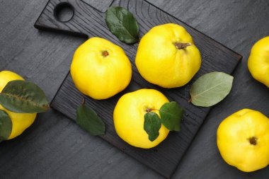 Olgun ayva ve yeşil yapraklar siyah desenli masa, düz yatıyordu.