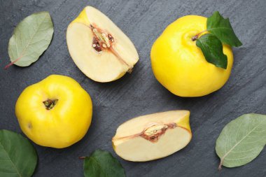 Olgun ayva ve yeşil yapraklar siyah desenli masa, düz yatıyordu.