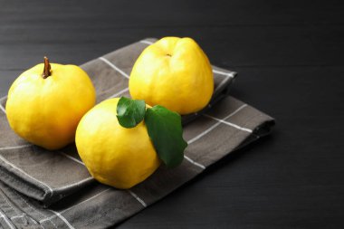 Siyah ahşap masanın üzerinde olgun ayva dişleri, yakın plan. Metin için boşluk