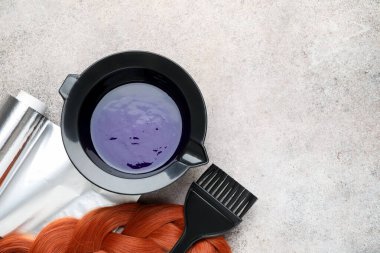 Kasede saç boyama ürünü, bir tutam saç ve açık gri masada farklı kuaför aletleri, düz yatak. Metin için boşluk