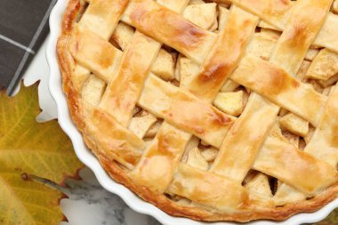 Lezzetli ev yapımı elmalı turta ve beyaz mermer masa üzerinde kuru yaprak.