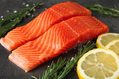 Somon fileto parçaları ve baharatlar gri masada, yakın plan.