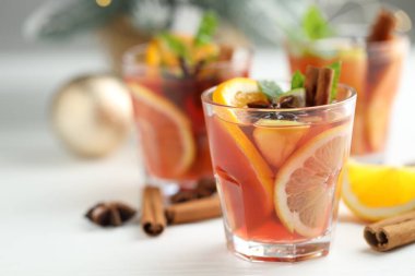 Bardaklı, baharatlı ve Noel dekorlu kokteyl beyaz masada, yakın plan. Metin için boşluk