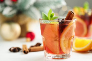 Bardakta kokteyl, baharat ve Noel süsü, beyaz masada, yakın plan. Metin için boşluk