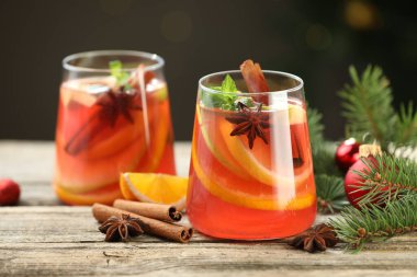 Gözlüklü, baharatlı ve Noel dekorlu lezzetli punç içeceği ahşap masada arka planda bulanık ışıklarla, yakın plan. Bokeh etkisi