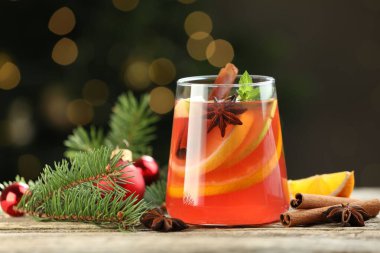 Cam, baharat ve Noel süsü katılmış lezzetli punç içecekler arka planda bulanık ışıklar ve yakın plan ile ahşap masa üzerinde. Bokeh etkisi