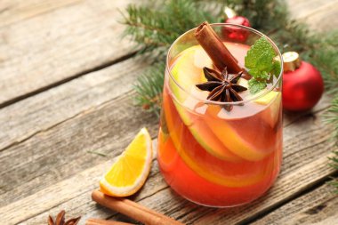 Bardakta kokteyl, baharat ve Noel süsü, ahşap masada, yakın plan. Metin için boşluk