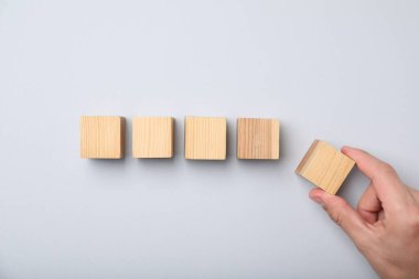 Hafif arka planda tahta küpleri olan adam, üst görünümde.