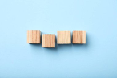 Açık mavi arkaplanda ahşap küpler, üst manzara