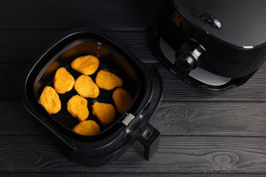 Tavuklu kızartma sepeti siyah ahşap masa üzerinde, düz yatıyordu. Metin için boşluk