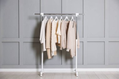 Gri duvarın yanında asılı farklı elbiseler.