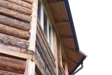 Gökyüzüne karşı ahşap duvarları ve pencereleri olan güzel bir bina, alçak açı manzaralı.