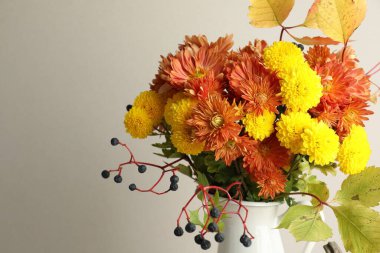 Sonbahar atmosferi. Güzel çiçekli vazo ve arka planda böğürtlen, yakın plan. Metin için boşluk