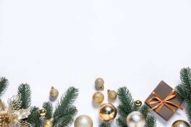 Köknar ağacı dalları ve beyaz arka planda Noel dekoru olan düz bir kompozisyon. Metin için boşluk