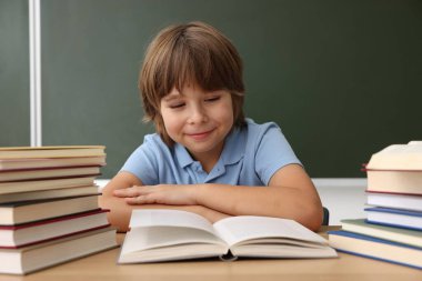 Okula dönelim. Çocuk masa başında karatahtaya karşı çalışıyor.