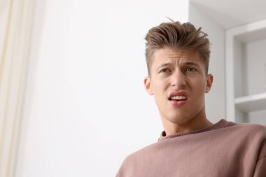 İçerideki kötü kokudan muzdarip genç adam, düşük açılı görüş. Metin için boşluk