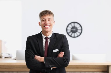 Resepsiyon masasının yanındaki üniformalı resepsiyonist.