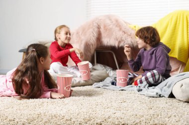 Evde yerde patlamış mısırla pijamalı şirin çocuklar.