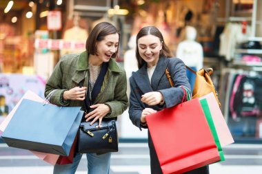 Alışveriş merkezlerinde farklı çantaları olan kadınlar.