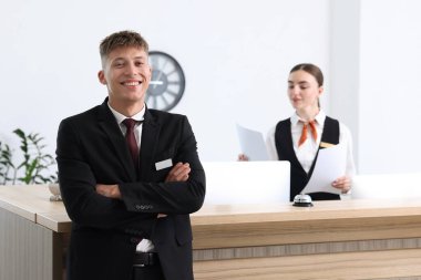 Otel resepsiyonunda çalışan resepsiyonist ve hostes, seçici odak