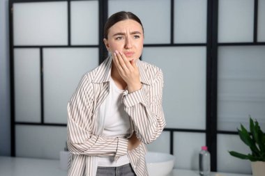 Banyoda mide ağrısı ve bulantısı olan bir kadın. Mesaj atmak için yer var.