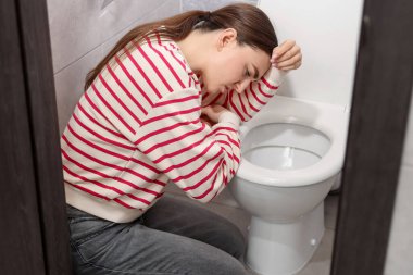 Tuvaletteki klozet yüzünden midesi bulanan kadın.