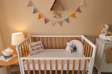 Beşik, masa, lamba ve dekorlu şık bir bebek odası. İç tasarım