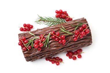 Lezzetli Noel kütüğü (geleneksel Noel pastası) kırmızı üzümlü ve köknar ağacı dallı beyaz, üst görünüm