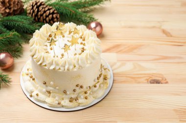 Açık ahşap masanın üzerinde Noel süsü olan lezzetli bir pasta. Metin için boşluk