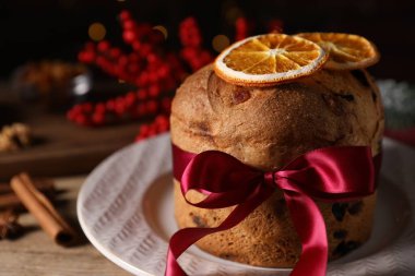 Noel yemeği. Lezzetli Panettone pastası, baharatlar ve ahşap masa üzerindeki şenlikli dekor, yakın plan.