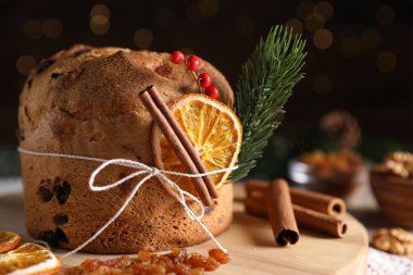 Noel yemeği. Lezzetli Panettone pastası, malzemeler ve arka planda arka planda bulanık ışıklarla süslü bir dekor, mesaj için yer. Bokeh etkisi