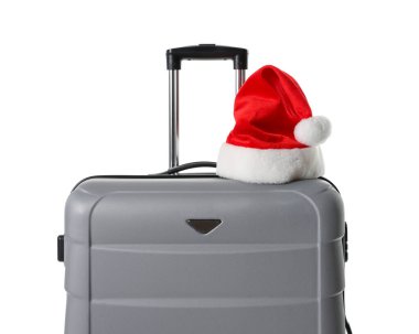 Beyaz üzerinde Noel Baba şapkası olan şık gri bavul. Noel tatili
