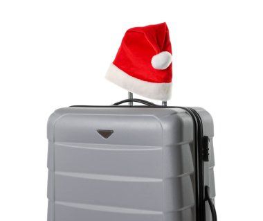 Beyaz üzerinde Noel Baba şapkası olan şık gri bavul. Noel tatili