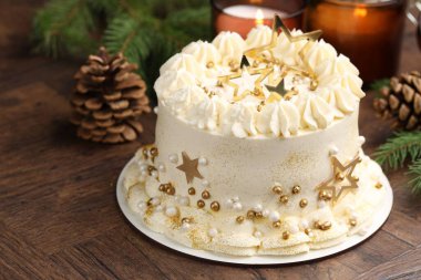 Noel dekorlu lezzetli pasta ve ahşap masada yanan mumlar, yakın plan.